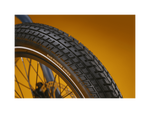 Close up of an ebike tire tread pattern against a gold background.
