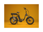 A matte black electric bike with a black passenger package against a gold background. 