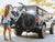 A person loads two ebikes onto a Sport Rider rack on the back of a vehicle